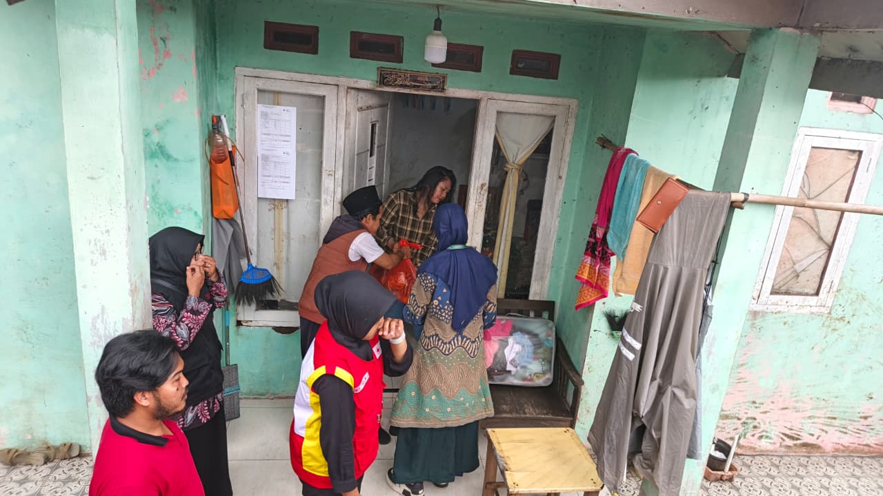 Petugas Posko Layanan Keagamaan distribusikan bantuan kepada warga terdampak.